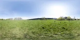 Grassy field with modern Warsaw apartment block under clear sunny sky in 17k HDR for realistic scene lighting.