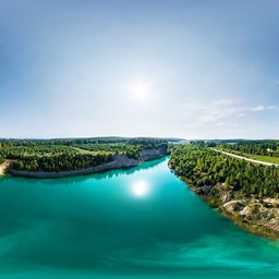 Turquoise lake with surrounding forests under clear skies for HDR scene lighting.