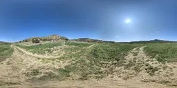 360-degree HDR panorama of a dry mud road leading through a mountainous landscape under a clear blue sky.