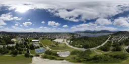 360-degree HDR panorama over city with parks, buildings, and dynamic sky for realistic lighting in 3D scenes.