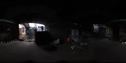 360-degree HDR panorama capturing a dimly lit home exterior with various objects and foliage.