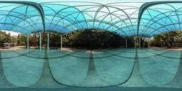 360-degree HDR panorama of an urban piazza with sunlight filtering through trees, casting dynamic shadows suitable for realistic scene lighting.