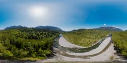 Panoramic HDR image of a river flowing through a lush green valley with Canadian mountains under a clear blue sky.