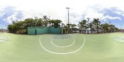 Outdoor green basketball court HDR with clear lines and palm trees under cloudy sky for 4K scene lighting.