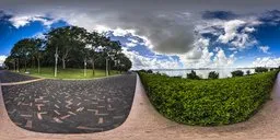 360-degree HDR image of a coastal scene with a winding brick path, lush foliage, and overcast sky.