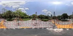 360-degree HDR panorama featuring a park with a trampoline, lush greenery, and clear skies.