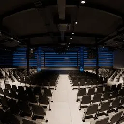 3D model of a modern auditorium with rows of seats and a lit stage, Blender creative professionals.