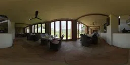 360-degree view of a sunlit interior dining space with large windows, elegant tables, and a natural outdoor backdrop.