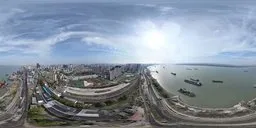 360-degree panoramic HDR image featuring a high-altitude view of a coastal pier and urban landscape with clear skies for scene lighting.