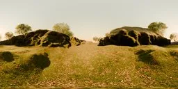 360-degree HDR panorama of a morning scene in a green landscape with rocks and grass.
