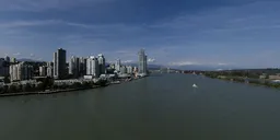 Aerial HDR panorama for lighting scenes featuring a riverfront metropolitan skyline under a clear blue sky.