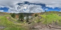 360-degree panoramic HDR of a cloudy mountain landscape with trees and a lake.