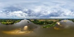 360-degree panoramic HDR image of a calm river with surrounding greenery under cloud-filled skies for scene lighting.