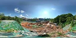 360-degree panorama of urban construction site with clear blue sky and excavators on yellow terrain