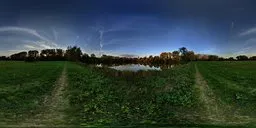 Panoramic view of a serene field with a lake, surrounded by trees under a clear sky, perfect for HDRI lighting in 3D scenes.