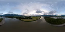 360-degree HDR image featuring a sunset over a river with cloudy skies and surrounding greenery.