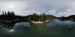 360-degree HDR panorama of serene lake surrounded by evergreen trees with reflective water under a partly cloudy sky.