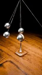 3D modeled pendulum on a wooden surface, reflecting light, perfect for Blender animation loops.