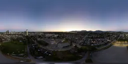 Dynamic aerial HDR panorama for lighting with vivid twilight glow and urban skyline.