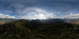 Aerial view HDR featuring dynamic lighting over lush hills and a striking cloudy sky at dusk.