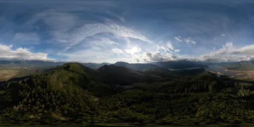 Aerial view HDR featuring dynamic lighting over lush hills and a striking cloudy sky at dusk.