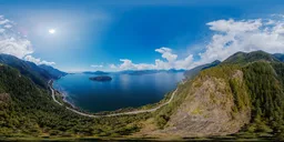 17k HDR panorama for scene lighting featuring a sunny day over mountains, ocean, and a cloudy sky.