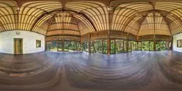 Tranquil HDR image of a serene leisure hall with a wooden arched ceiling and panoramic windows overlooking greenery.