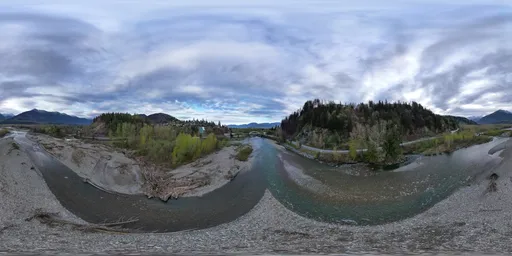 360-degree HDR panorama showcasing a river winding through mountainous terrain under a moody overcast sky.