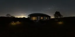 360-degree night-time HDR showing a house with illuminated windows, lush lawn, trimmed hedges, and purple flowers.