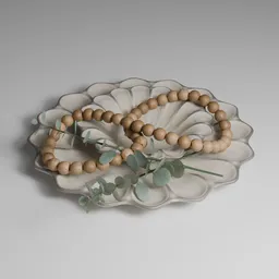 Interior decoration piece:  wooden bead garlands and  eucalyptus branch on top of porcelain bowl plate