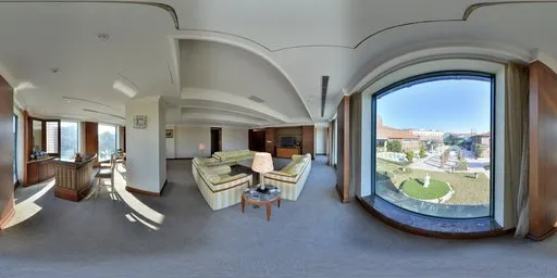 360-degree view of a spacious hotel room with curved architecture, natural lighting, and elegant furnishings.