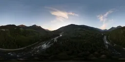 Dynamic aerial HDR panorama of a vibrant sunset over mountains with river and lush greenery for scene lighting.