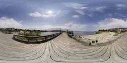 Wooden quay leading to a sunlit ocean with clear skies, perfect for realistic lighting in 3D renders.