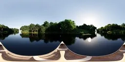 360-degree HDR panorama of a tranquil river with trees under a clear blue sky, and a lone bird in flight for scene lighting.