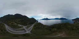 Panoramic HDR for realistic lighting featuring aerial mountainous terrain with highway and ocean inlet under overcast sky