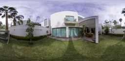 360-degree HDR of a suburban garden with swing, terrace, and modern home with expansive windows and a perimeter wall.