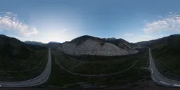 High-resolution HDR panorama for 3D lighting, showing a valley road at sunset with mountainous terrain.