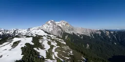 Aerial view of a lush Canadian mountain landscape with snow patches under clear blue skies, perfect for HDR lighting in 3D scenes