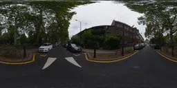 360-degree panoramic view of an overcast city street corner with buildings and parked cars for HDR lighting.
