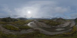 360-degree HDR panorama of aerial river valley with sun over Canadian mountains.