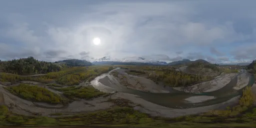 360-degree HDR panorama of aerial river valley with sun over Canadian mountains.