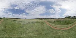360-degree HDR panorama showcasing varied cloud formations above a natural grassy landscape with a dirt path.