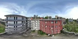 360-degree HDR panorama of urban scenery with red and white apartment buildings under a blue sky.