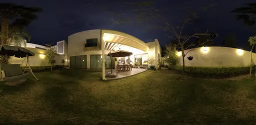 Evening ambiance in a well-lit outdoor space with modern architecture, ideal for scene lighting references.