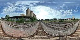 16K HDR image featuring expansive cloudy sky above converging railway tracks with urban architecture.