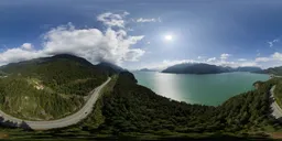 High-resolution HDR image showing a coastal road, ocean, and mountains under a sunny sky, ideal for realistic lighting in 3D scenes.