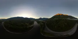 Dynamic HDR panorama of a sunrise over Canadian mountains with a winding river and roadway.