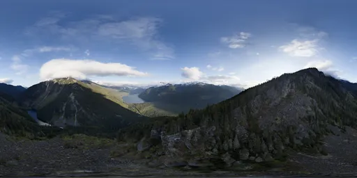 High-resolution HDR panorama featuring a soaring mountain range, lush greenery, and clear skies for scene lighting.