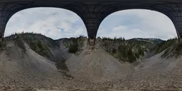 360-degree HDR panoramic image featuring the underside of a bridge with surrounding Canadian mountains and sky.