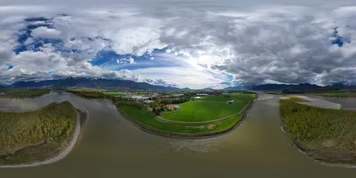 360-degree HDR panorama showing the contrast of sunlight and shadows over a expansive valley surrounded by mountains.